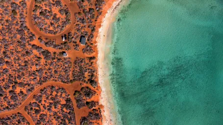 Red sand bushland with beach and blue ocean
