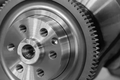 Close up for a round steel cog with six screw holes