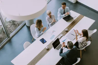Overhead shot of 5 colleagues working at a table