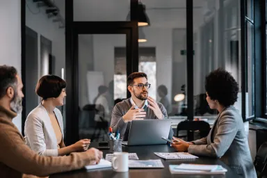Four people discussing work at a table