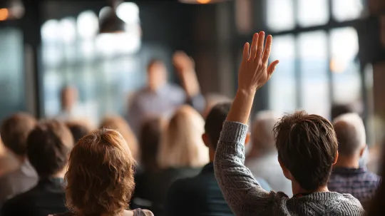 Hand raised from audience during Q&A session