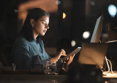 Women working on an ipad in a dark room